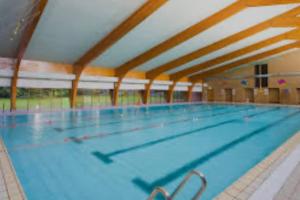 a large indoor swimming pool with blue water at Central 1st Class in Quiet Location in Galashiels