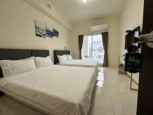 a bedroom with two beds and a large window at Ming House in Taitung City