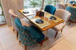una mesa de madera con sillas azules y una mesa con platos. en Treebo Trend Oasis Cuttack Puri, en Bhubaneshwar