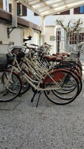 eine Reihe von Fahrrädern, die neben einem Gebäude geparkt sind in der Unterkunft Hotel Tognon in Grado