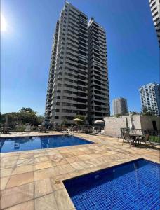 a swimming pool in front of two tall buildings at Belíssimo Apartamento Beira Mar em Ótima Localização in Rio de Janeiro