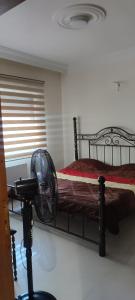 a bedroom with a bed with a fan and a window at apartments furnished for rent in Amman Jordan in Amman