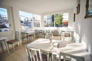 un restaurante vacío con mesas, sillas y ventanas en Hotel Pelayo en Mar del Plata