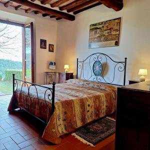 a bedroom with a bed and a large window at casa vacanze nel Chianti il Granaio in Castellina in Chianti