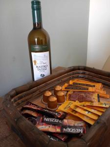 a bottle of wine sitting next to a basket of food at Elli Beach Downtown Apartments in Rhodes Town