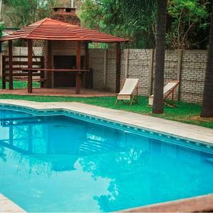 einen Pool mit einem Picknicktisch und einem Pavillon in der Unterkunft Las Palmas in Mercedes