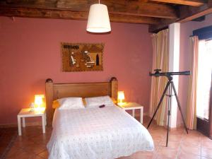 Un dormitorio con una cama y una cámara en un trípode en Apartamentos Valdelinares, en Valdelinares