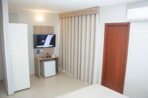 a room with a door and a television in it at Citi Executivo Hotel in Parnaíba