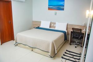 a bedroom with a bed and a desk and a chair at Citi Executivo Hotel in Parnaíba