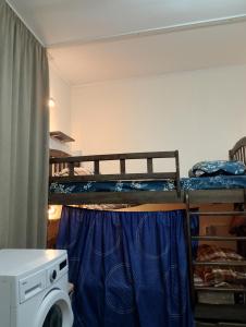 Pokój z 2 łóżkami piętrowymi i pralką w obiekcie El Hostal w mieście Tbilisi City