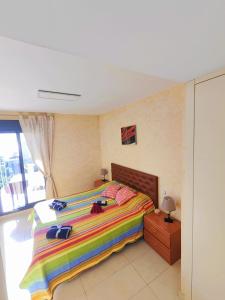 ベニドルムにあるMirador Lux Residenceのベッドルーム1室(大型ベッド1台、カラフルな毛布付)