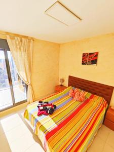 ベニドルムにあるMirador Lux Residenceのベッドルーム1室(カラフルな毛布付きのベッド1台付)
