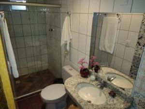 a bathroom with a sink and a toilet and a shower at Ayo Bistrô Pousada in Marau