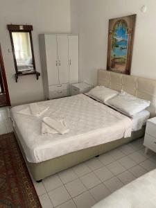 1 dormitorio con 1 cama grande y espejo en Sevgi Hotel Kalkan, en Kalkan