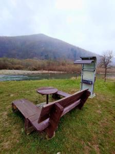 un tavolo da picnic e una panchina in un campo di Villa Opir a Skole
