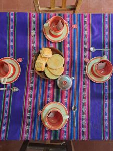 a table with plates and cups of tea and bread at Las Moras in Maimará