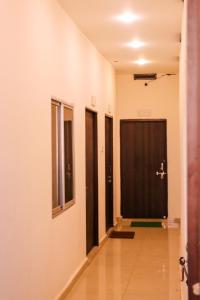 un corridoio di una stanza con porte nere di ROYAL PALACE BY RAJASTHAN MAHESHWARI BHAWAN a Katni