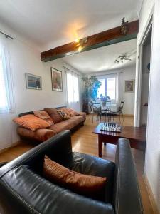 a living room with two leather couches and a table at Appartement Casa Catala in Canet-en-Roussillon