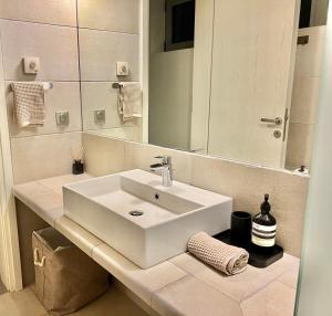 a bathroom with a white sink and a mirror at Ippolitus Feliz in Kos Town +9 photos