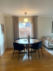 uma mesa de jantar e cadeiras numa sala de estar em Flott 4-roms leilighet til leie em Trondheim