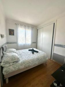 a bedroom with a bed with a hat on it at Appartement Casa Catala in Canet-en-Roussillon