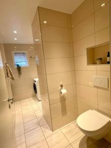uma casa de banho com um WC e uma cabina de duche em vidro. em Flott 4-roms leilighet til leie em Trondheim