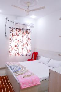 1 dormitorio con 1 cama y ventana con silla roja en ROYAL PALACE BY RAJASTHAN MAHESHWARI BHAWAN, en Katni