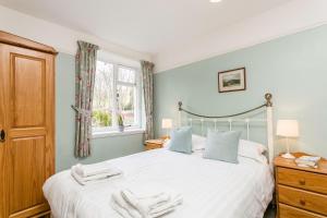 a bedroom with a bed with two towels on it at April Cottage in Minehead