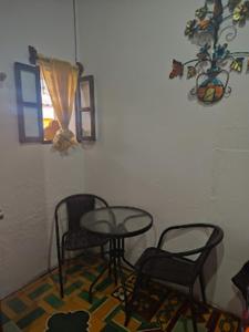 mesa y sillas en una habitación con ventana en La Merced en Antigua Guatemala