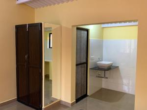 博格馬洛的住宿－Elite Guest House Bogmalo，一间带玻璃淋浴和水槽的浴室