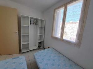 Ένα ή περισσότερα κρεβάτια σε δωμάτιο στο Confortable 2 pièces, 4 couchages avec balcon et parking privé, proche plage - Marseillan - FR-1-326-596