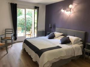 a bedroom with a large bed and a window at Villa de Charme au coeur du Cap-Ferrat in Saint-Jean-Cap-Ferrat