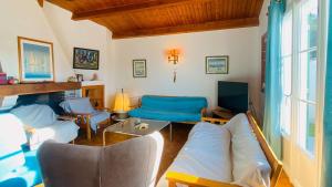 uma sala de estar com um sofá e uma televisão em A proximité de la plage et du centre village, villa tout confort em Le Bois-Plage-en-Ré