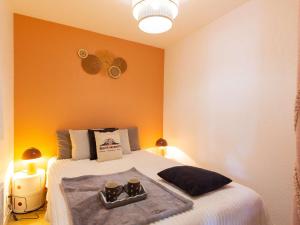 ein Schlafzimmer mit einem Bett mit zwei Tassen drauf in der Unterkunft Appartement Saint-Lary-Soulan, 2 pièces, 6 personnes - FR-1-296-159 in Saint-Lary-Soulan