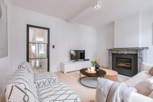 sala de estar con muebles blancos y chimenea en Charming house in the city of Antwerp with parking, en Amberes