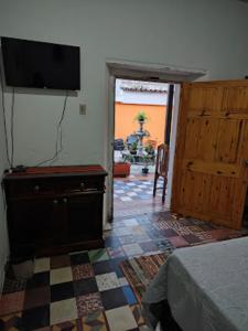 1 dormitorio con TV en la pared y suelo en La Merced en Antigua Guatemala