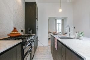 cocina con fregadero y fogones horno superior en Charming house in the city of Antwerp with parking, en Amberes