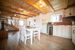 a kitchen with a white table and chairs in a room at Penzion Mája in Pavlov