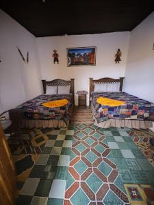 a room with two beds and a rug at La Merced in Antigua Guatemala