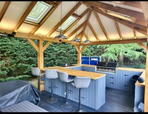 an outdoor kitchen with a table and stools at Catton Old Hall Norwich in Norwich