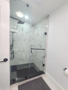 a shower with a glass door in a bathroom at Modern East York Retreat 20 mins to DT Toronto in Toronto