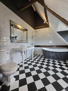 y baño con aseo, lavabo y bañera. en Catton Old Hall Norwich en Norwich