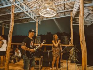 un hombre y una mujer tocando la guitarra en un escenario en Funky Moon Kampot en Kampot