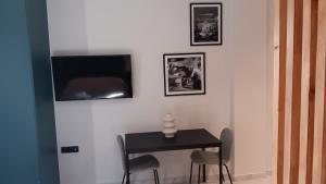 a room with a table and a tv on a wall at B2 Urban Studio in Larisa