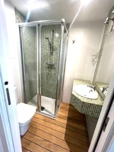 uma casa de banho com um chuveiro, um WC e um lavatório. em alojamiento Tinajas em La Coruña