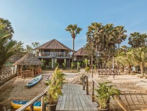 a house on a beach with a boat on the sand at Funky Moon Kampot in Kampot