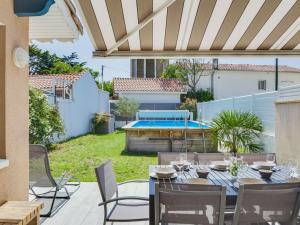 patio ze stołem i krzesłami oraz basenem w obiekcie Maison Capbreton, 4 pièces, 8 personnes - FR-1-413-87 w mieście Capbreton