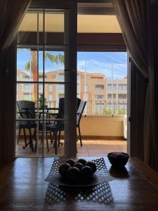 stół z miską owoców na stole przed oknem w obiekcie Apartamento Deluxe Vistas Laterales al Mar w mieście Isla Canela