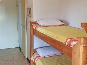 1 Schlafzimmer mit 2 Etagenbetten mit gelber Bettwäsche in der Unterkunft Studio Bormes-les-Mimosas, 1 pièce, 4 personnes - FR-1-610-17 in Bormes-les-Mimosas
