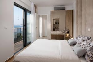 a bedroom with a large white bed and a large window at Villa Palm Bay 1, heated pool - 5 m from the sea in Ražanj